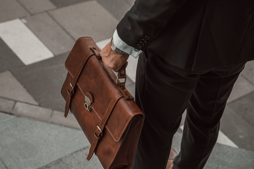 man carrying brown messenger briefcase
