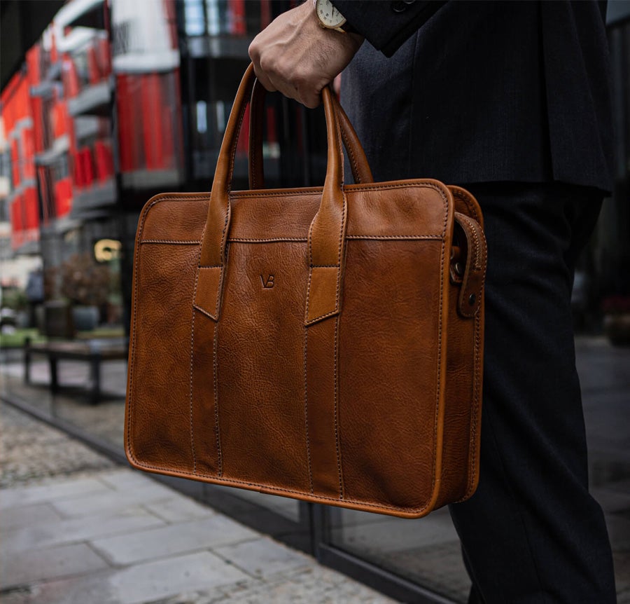 Exquisite tan leather laptop bag held by man in suit