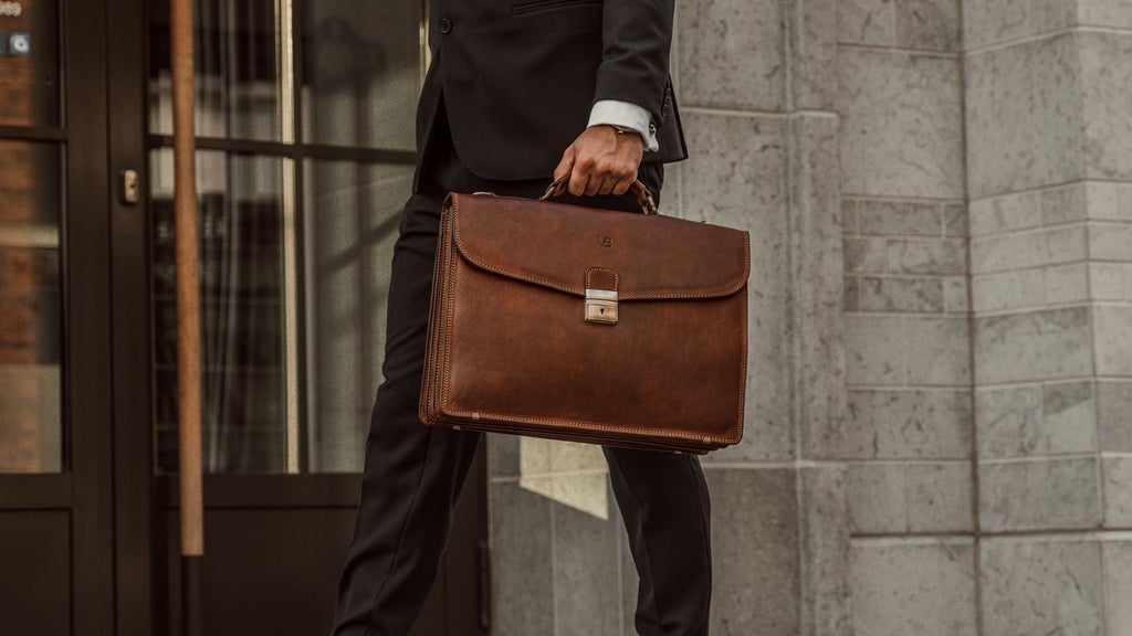 no1 briefcase in brown held by man in suit on steps
