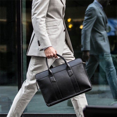 black leather briefcase carried by man in suit