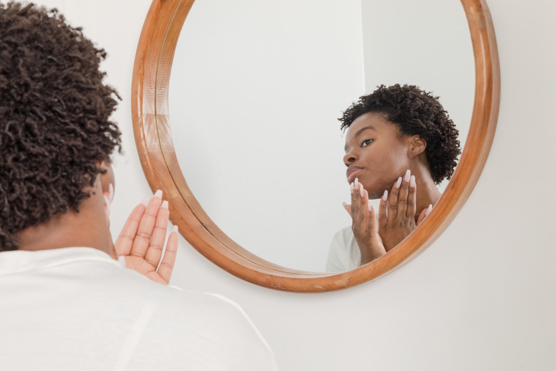 Woman looking at her skin in a mirror