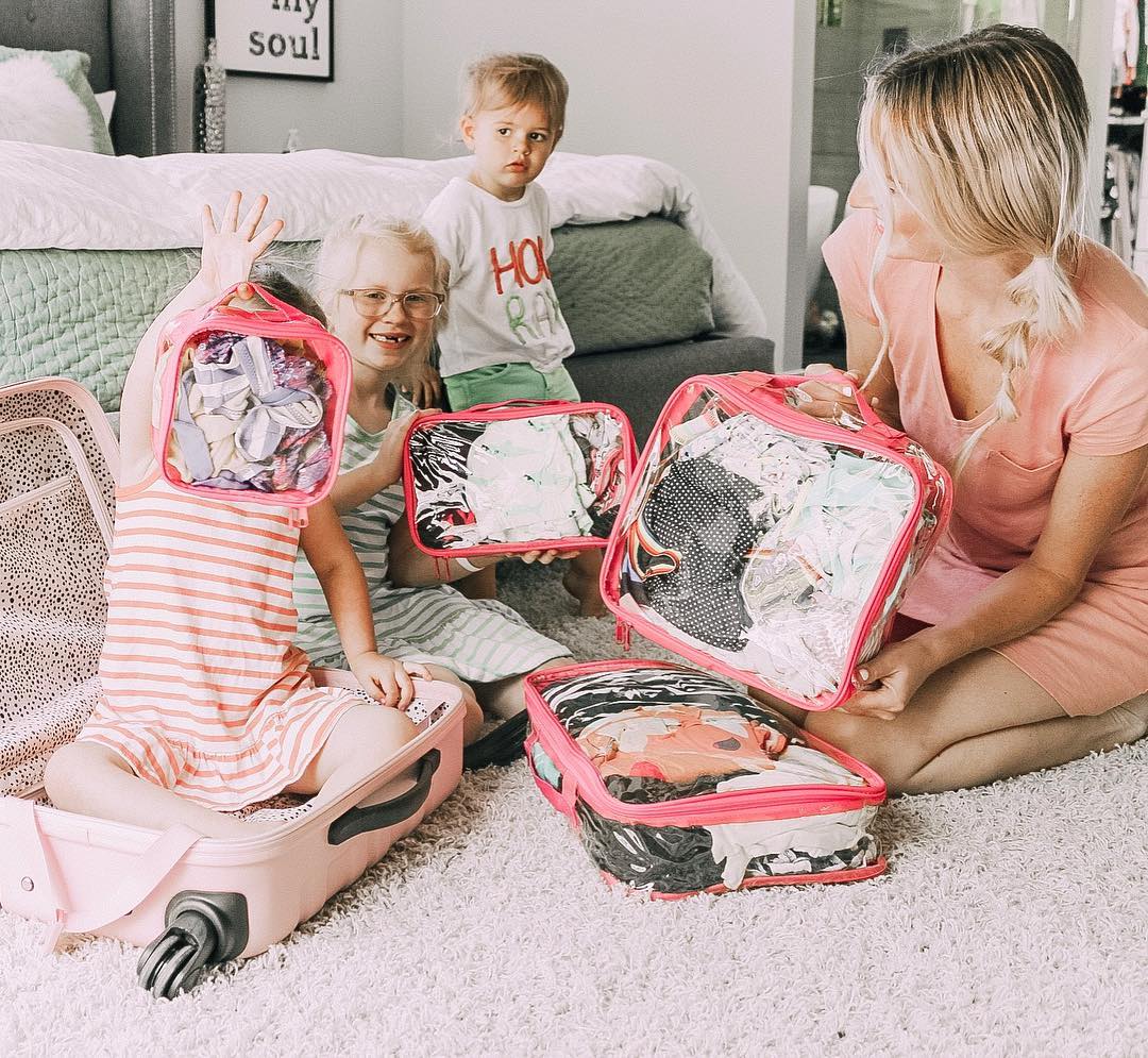 Mom with kids and travel essentials packed in Starter Set of packing cubes
