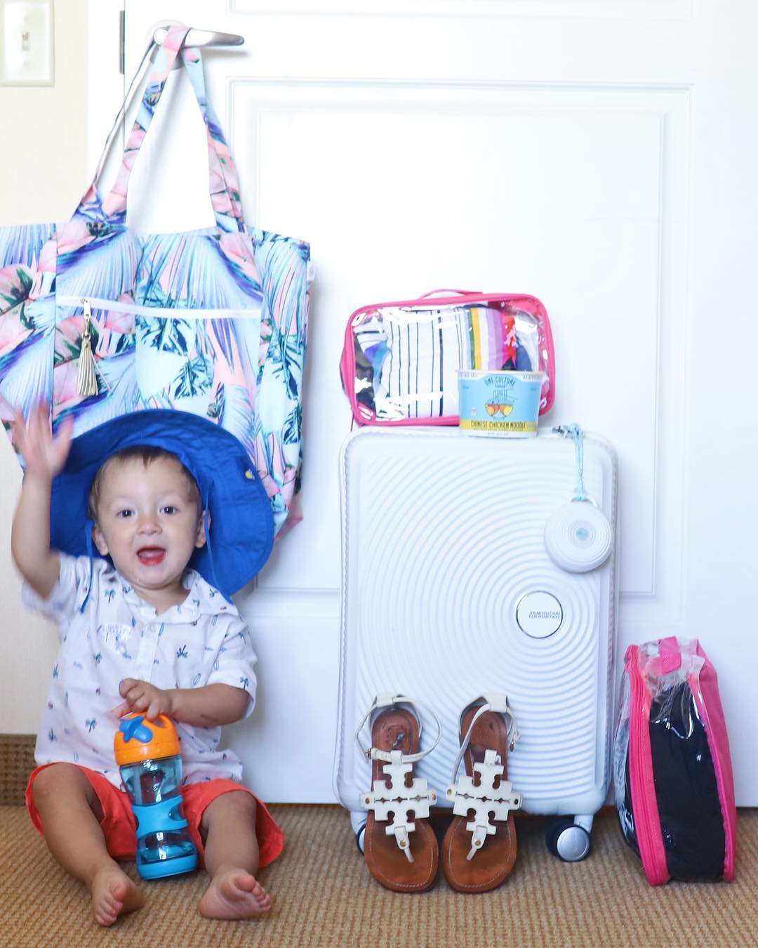 Baby beside packed essentials for a trip