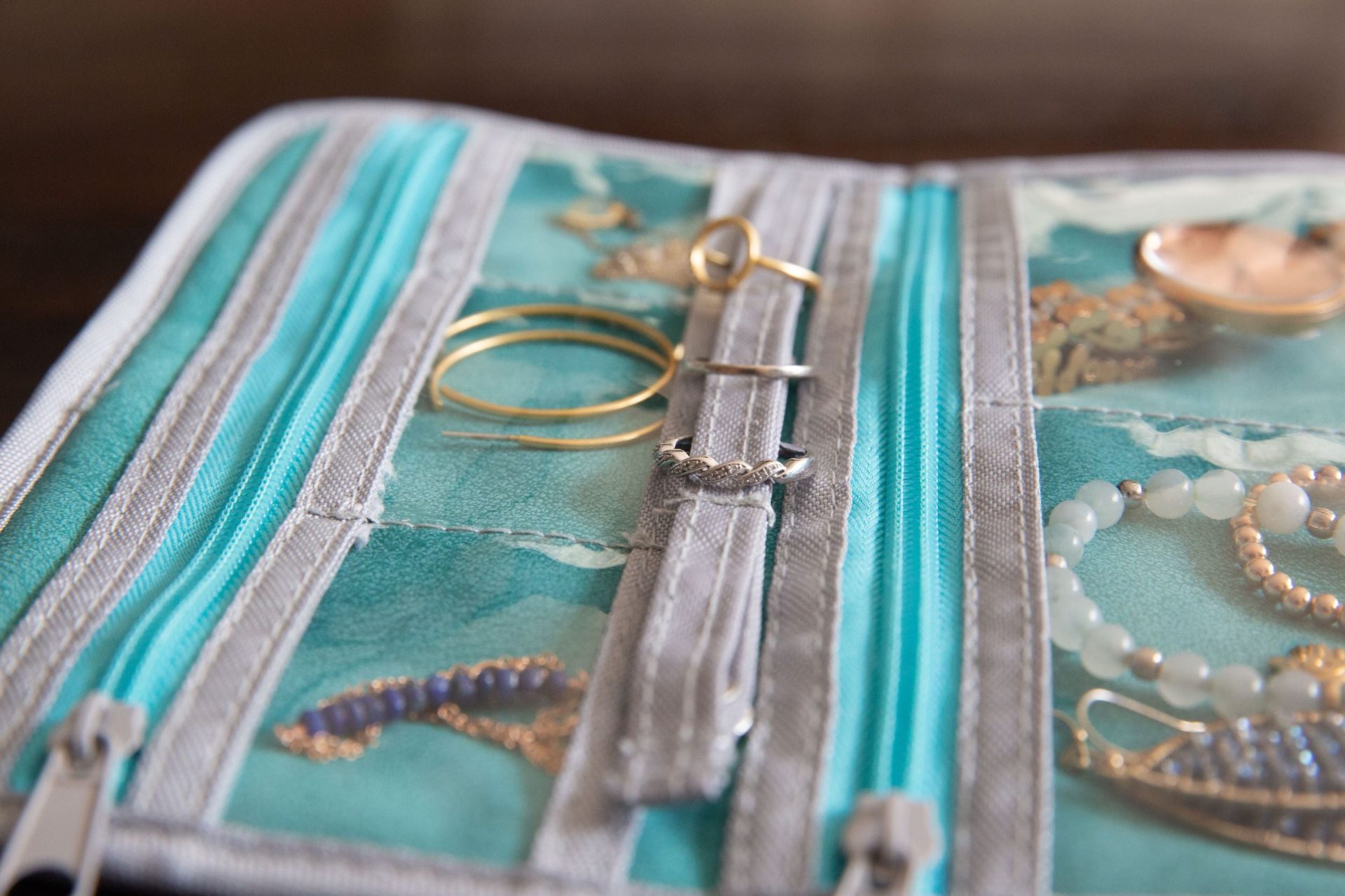 Top compartment for earrings in a travel jewelry roll