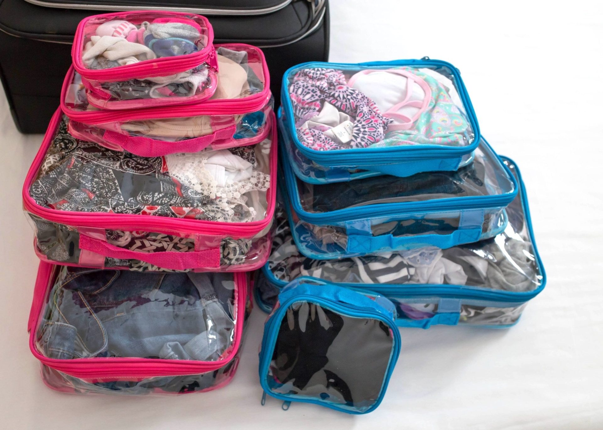 A set of pink and blue clear packing cubes for travel