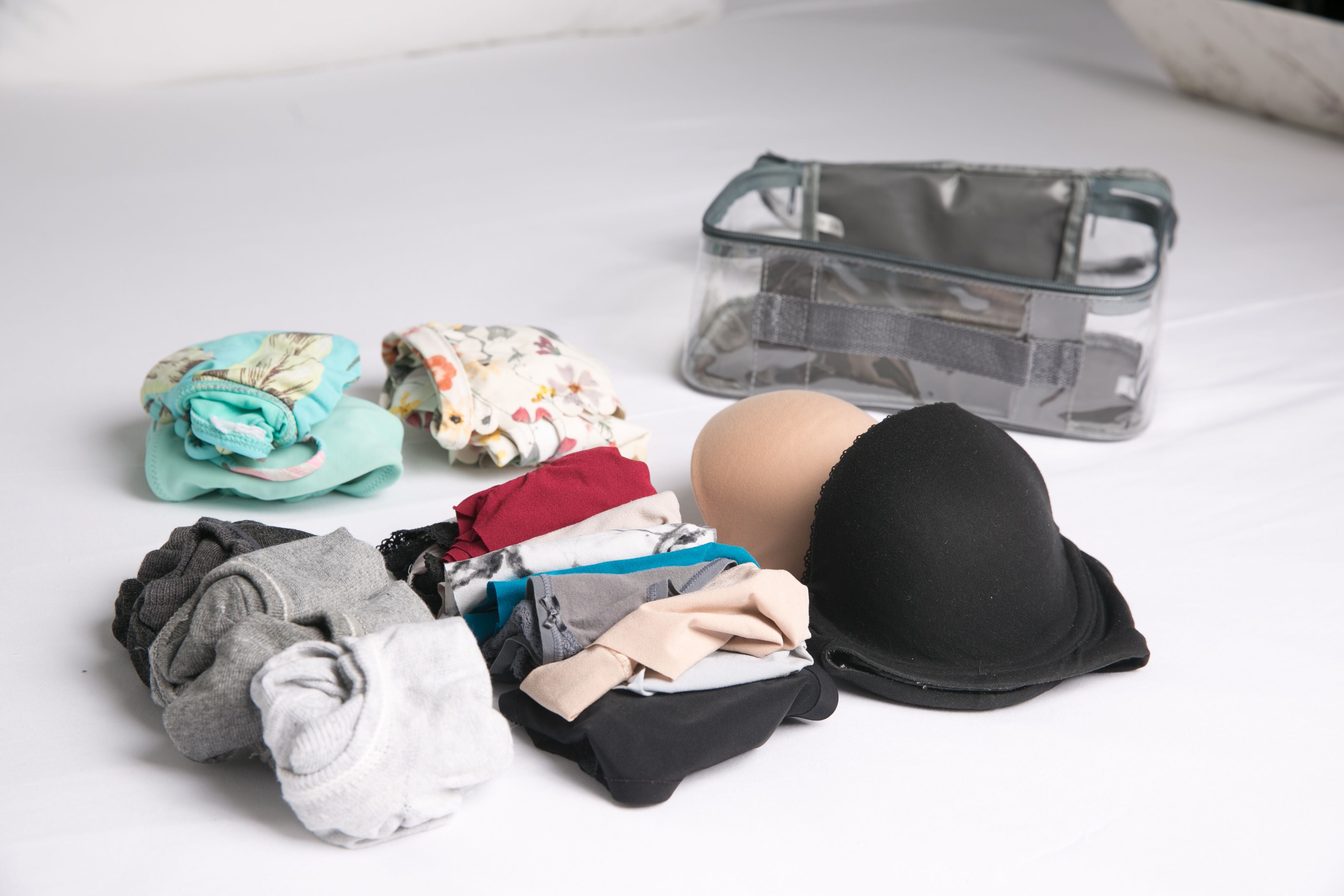 Undergarments rolled beside small packing cube