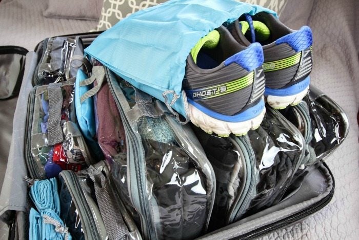 Pair of shoes in a travel shoe bag on top of suitcase