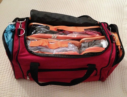 Orange packing cubes inside a duffel bag