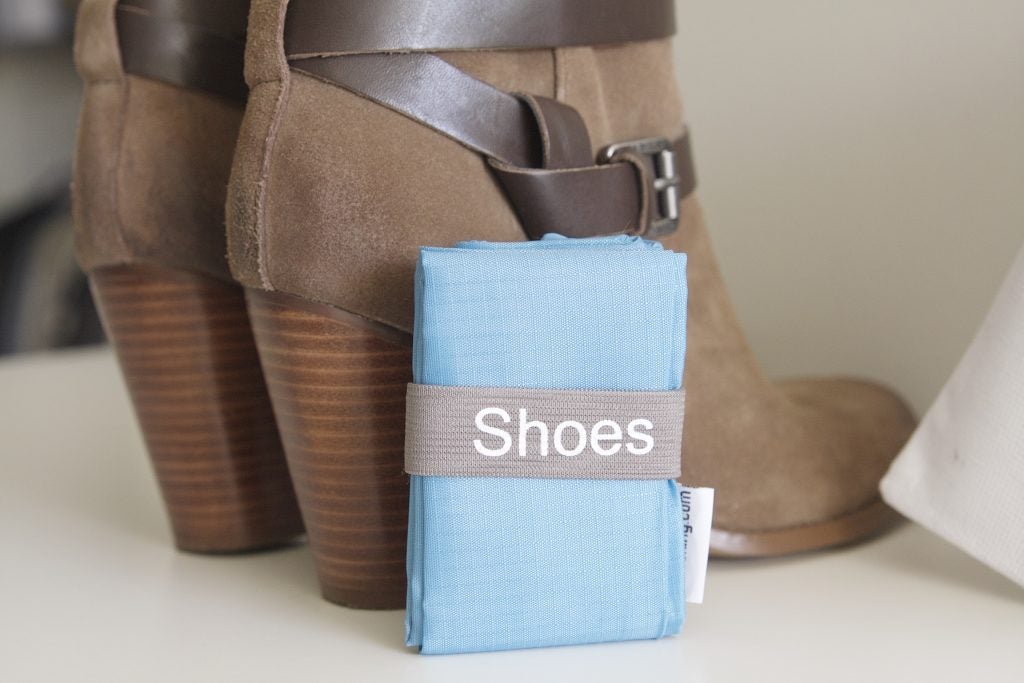 A pair of boots and folded travel shoe bag