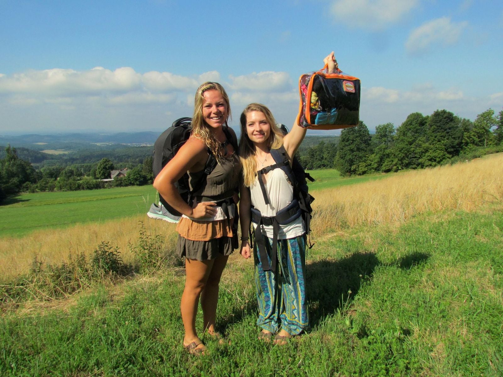 two ladies on a hiking trip with a large orange cube
