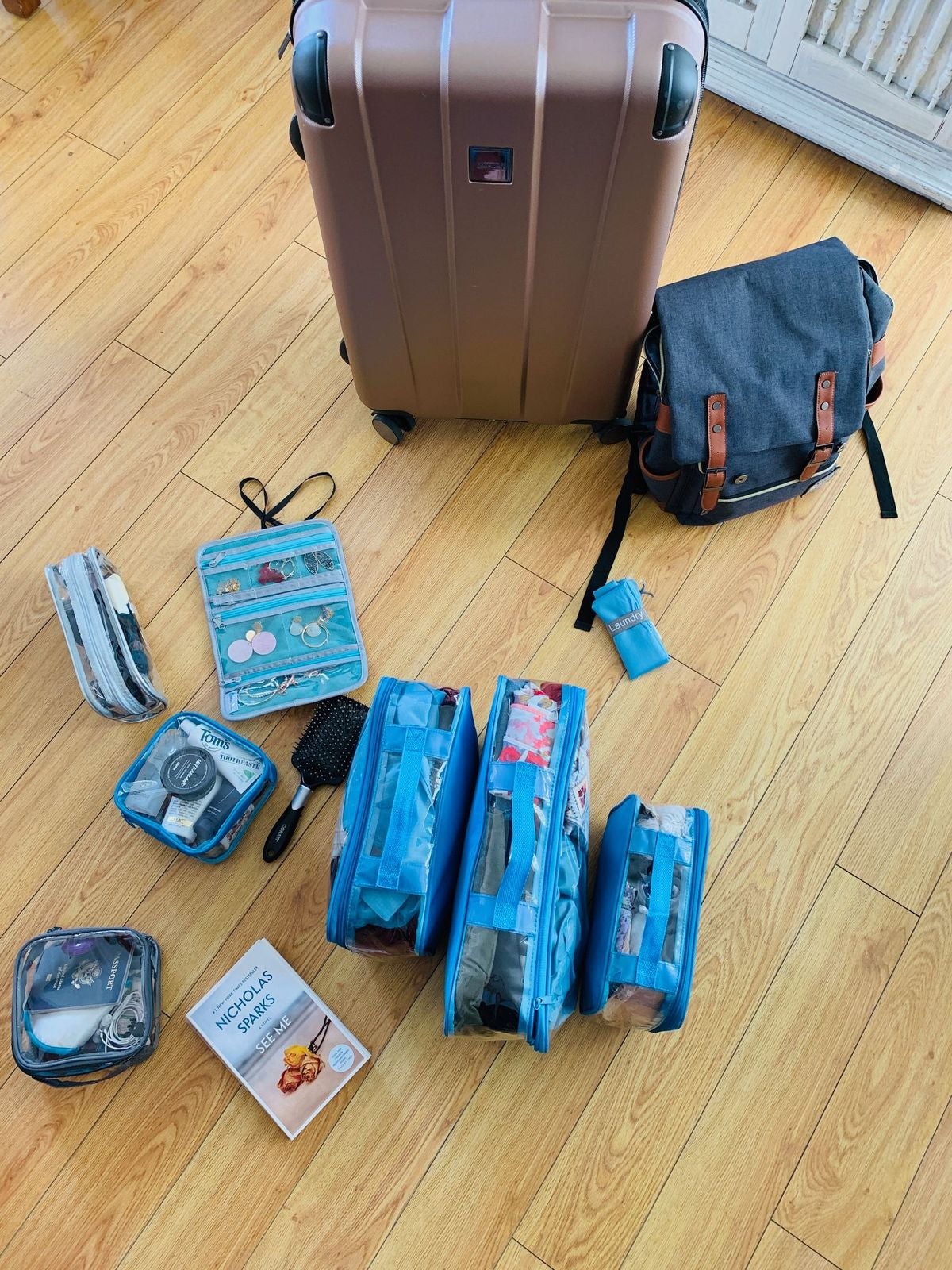 travel essentials organized in turquoise clear packing cubes