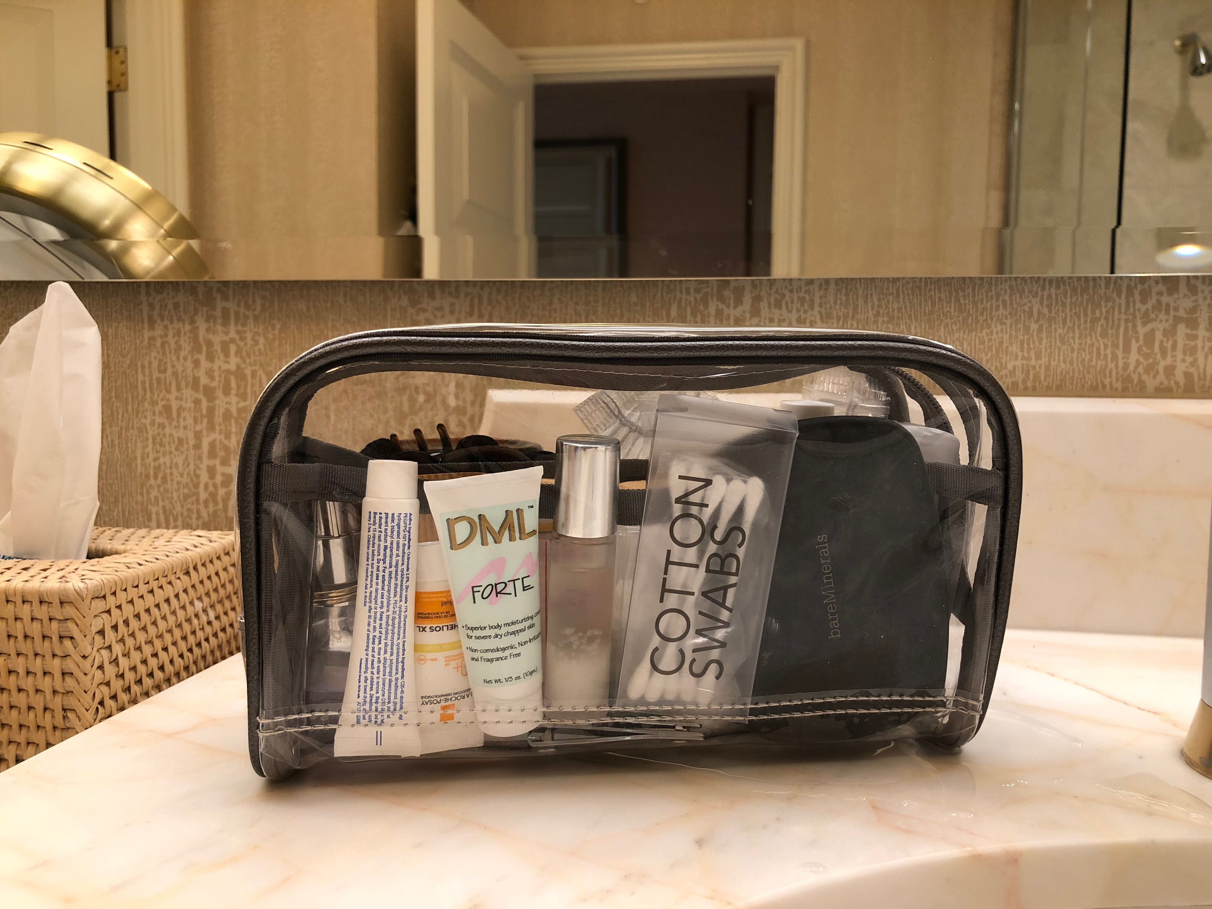 Weekend trip essentials on a clear makeup bag