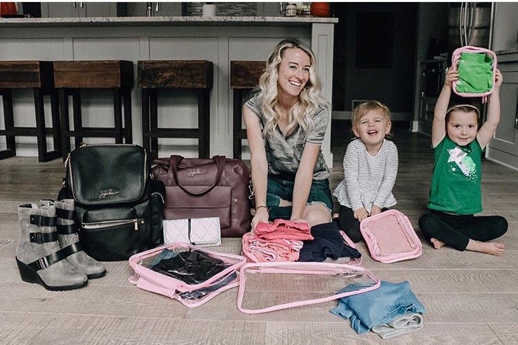 Mom with with kids using travel cubes for packing backpack