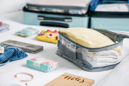 Gray packing cubes for travel organizer inside a carry-on luggage