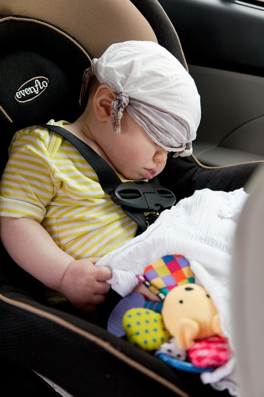 Baby sleeping on car seat during road trip