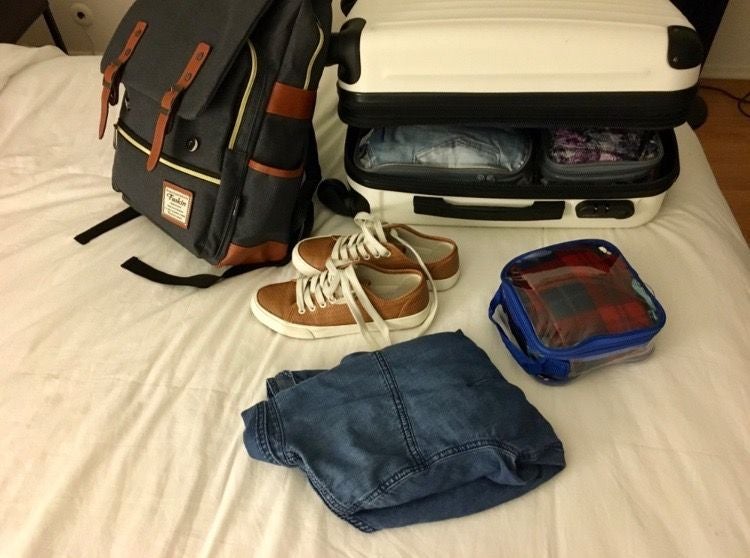backpack, a suitcase, shoes, a jacket, and an extra small packing cube