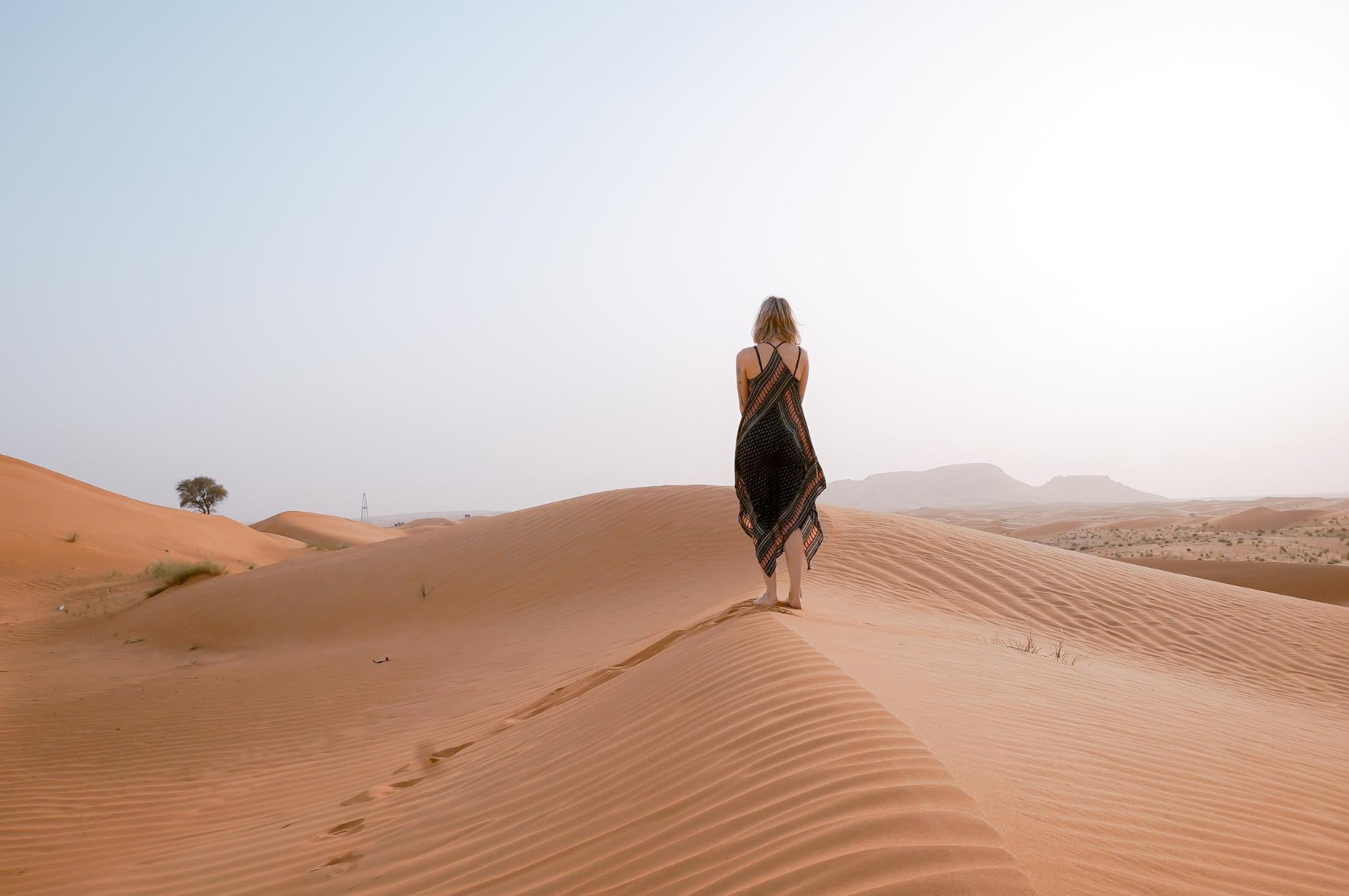 Medium haired girl traveling on a desert alone on a sunny day