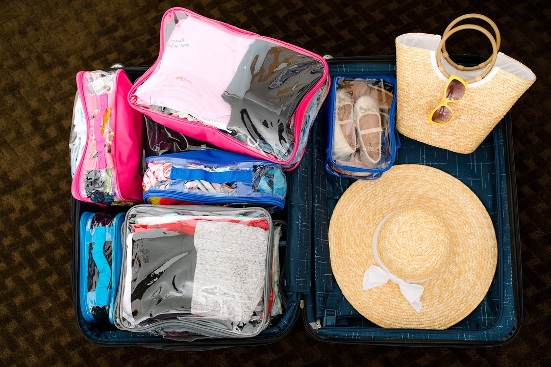 Summer vacation essentials organized in clear packing cubes
