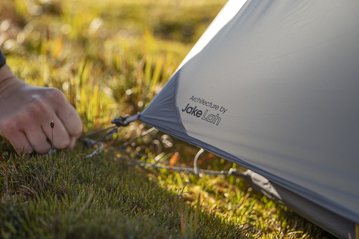 Close up of hand fastening tent fly