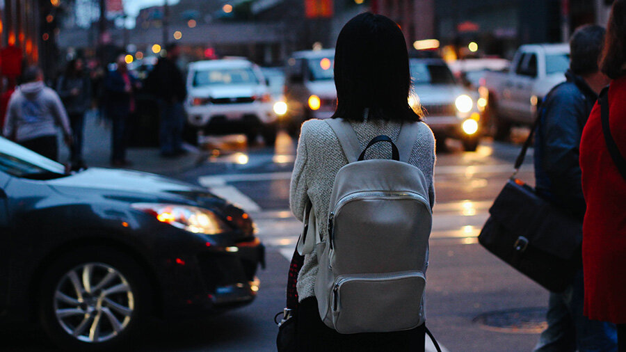 Woman walking in the city with a backpack on