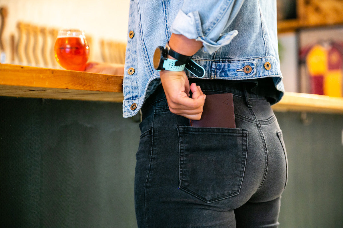 Woman pulling an Allett leather ID wallet out of her back pocket