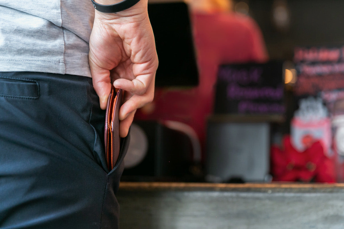 Close up of a man pulling an Allett leather Hybrid Card Wallet out of his front pocket
