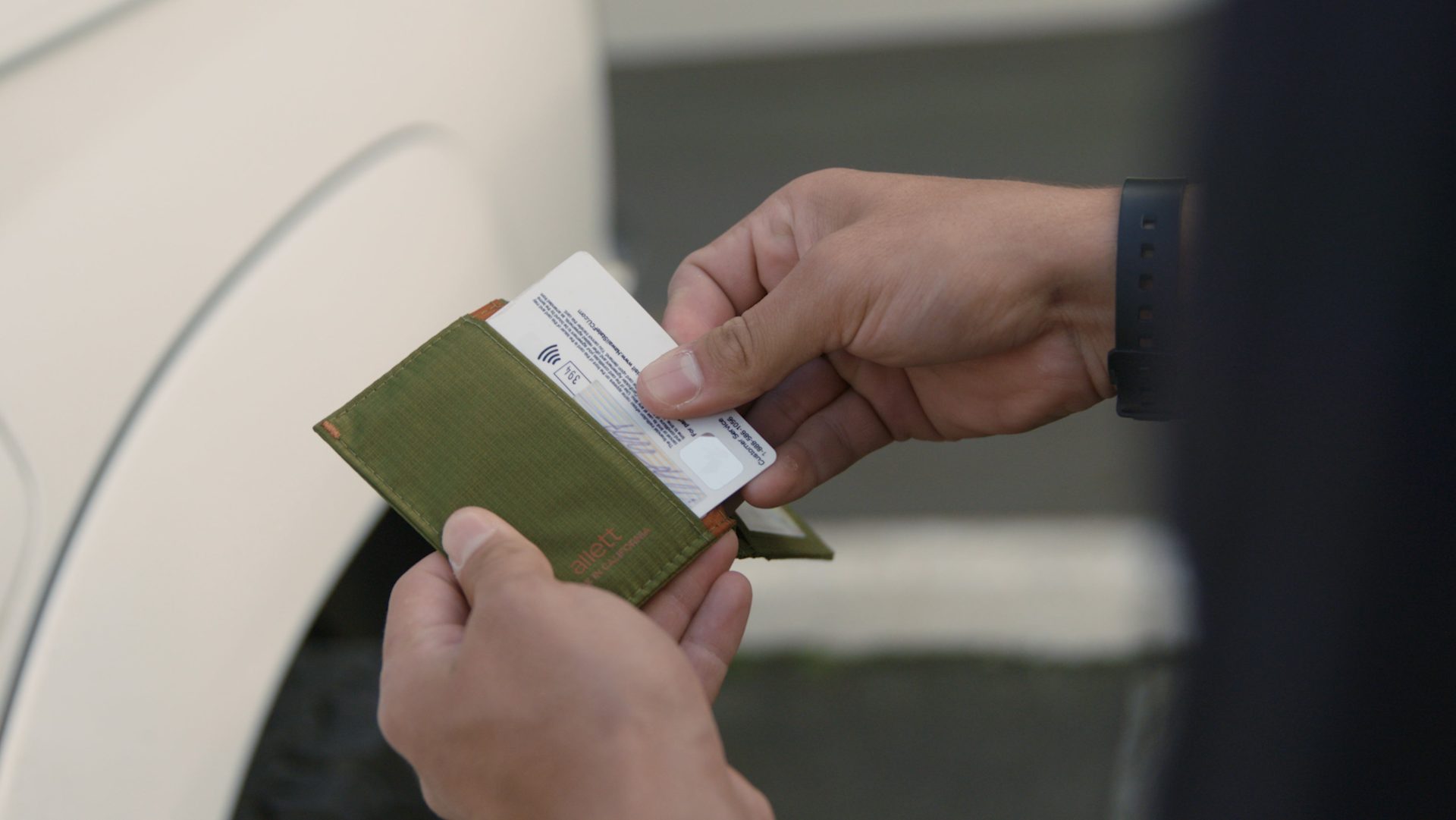Person pulling credit card out of an Allett slim RFID-Blocking wallet