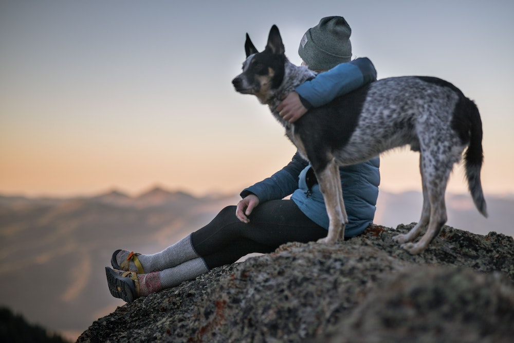 Woman hiking in the mountains with her dog