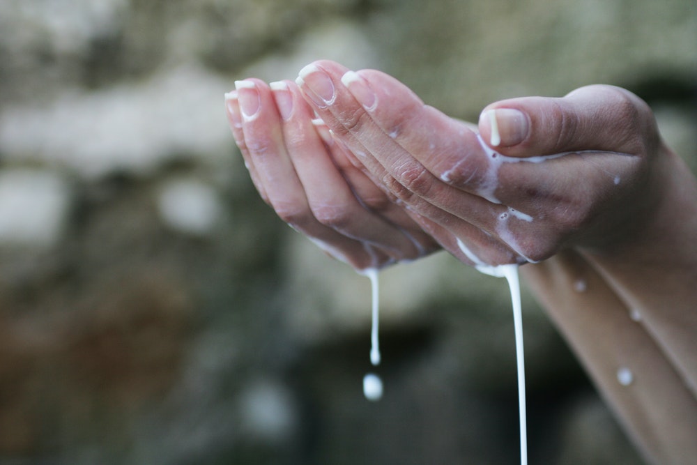 Persons hands covered in white water