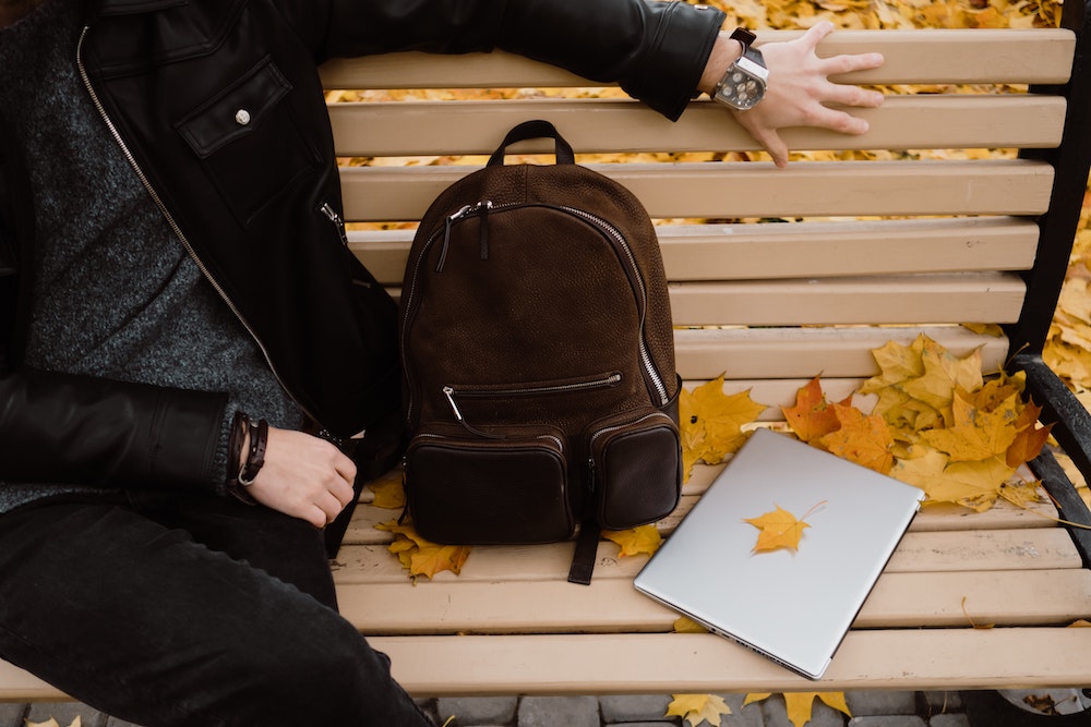 A laptop and backpack on the bench