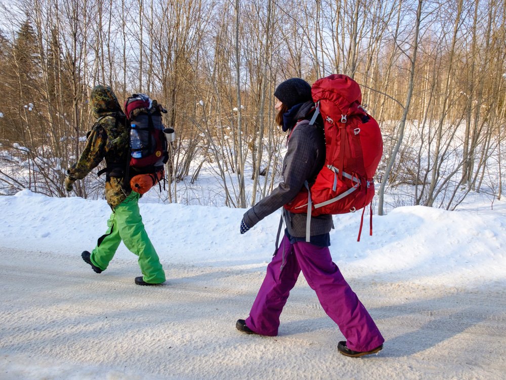 People with backpacks walking on the road