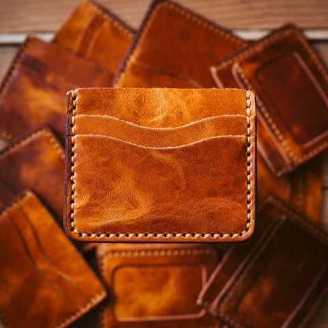A stack of leather card wallets with one framed in the light