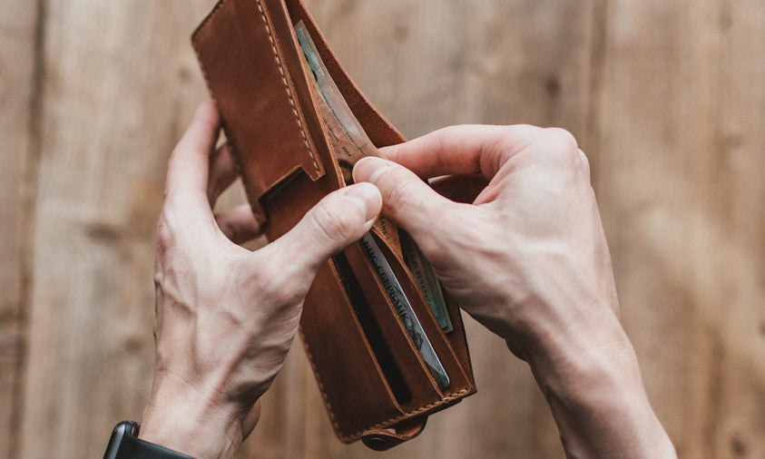 man using a wallet to carry cash
