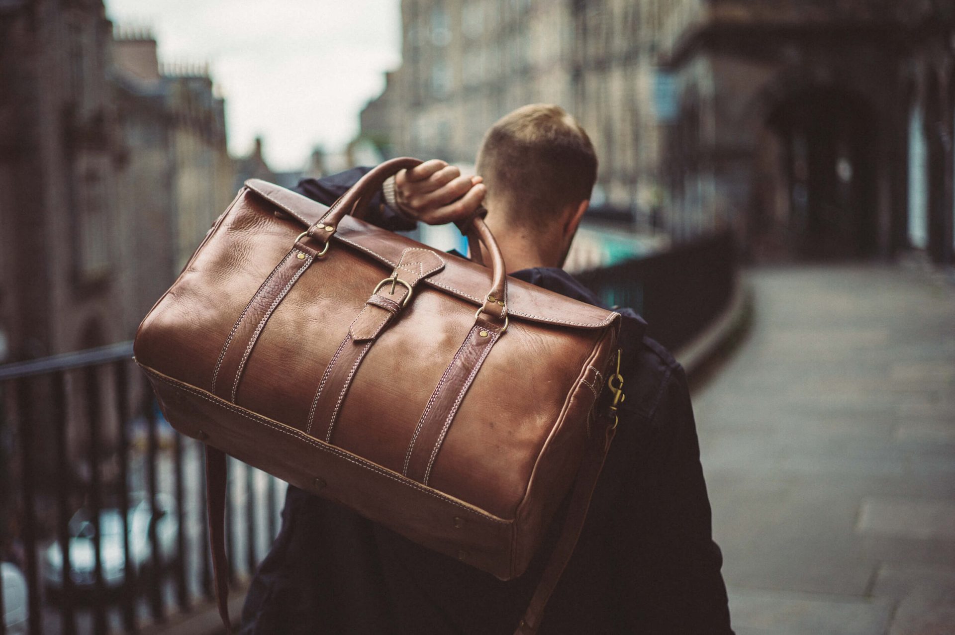 Brown leather travel bag handstitched with full grain vegetable tanned leather carried by man in Edinburgh Scotland.jpg