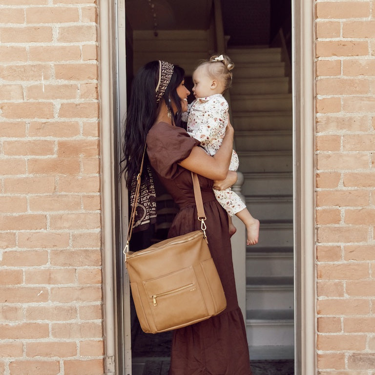 mom holding her daughter in a stairwell door
