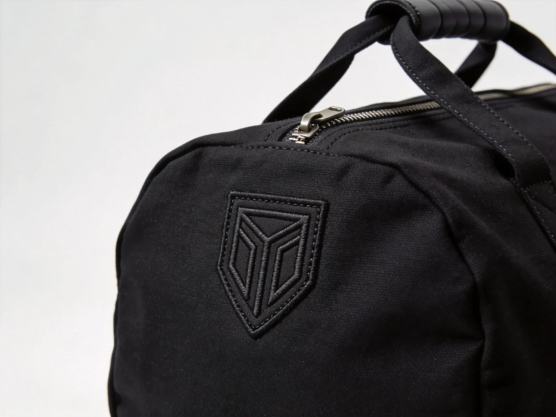 embroidered logo detail on a custom duffle bag with reinforced handles