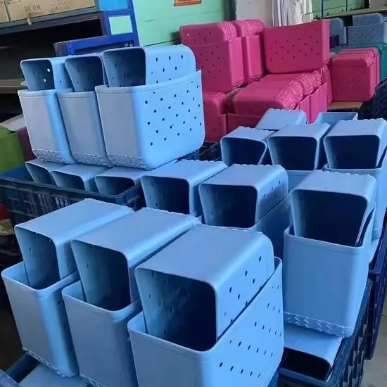 Stacked colorful EVA molded tote bags in factory warehouse showing bulk production of Bogg-style rubber beach bags