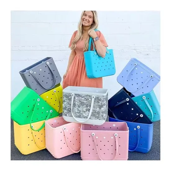 Woman showcasing multiple colorful EVA Bogg-style rubber tote bags demonstrating the wide color range available