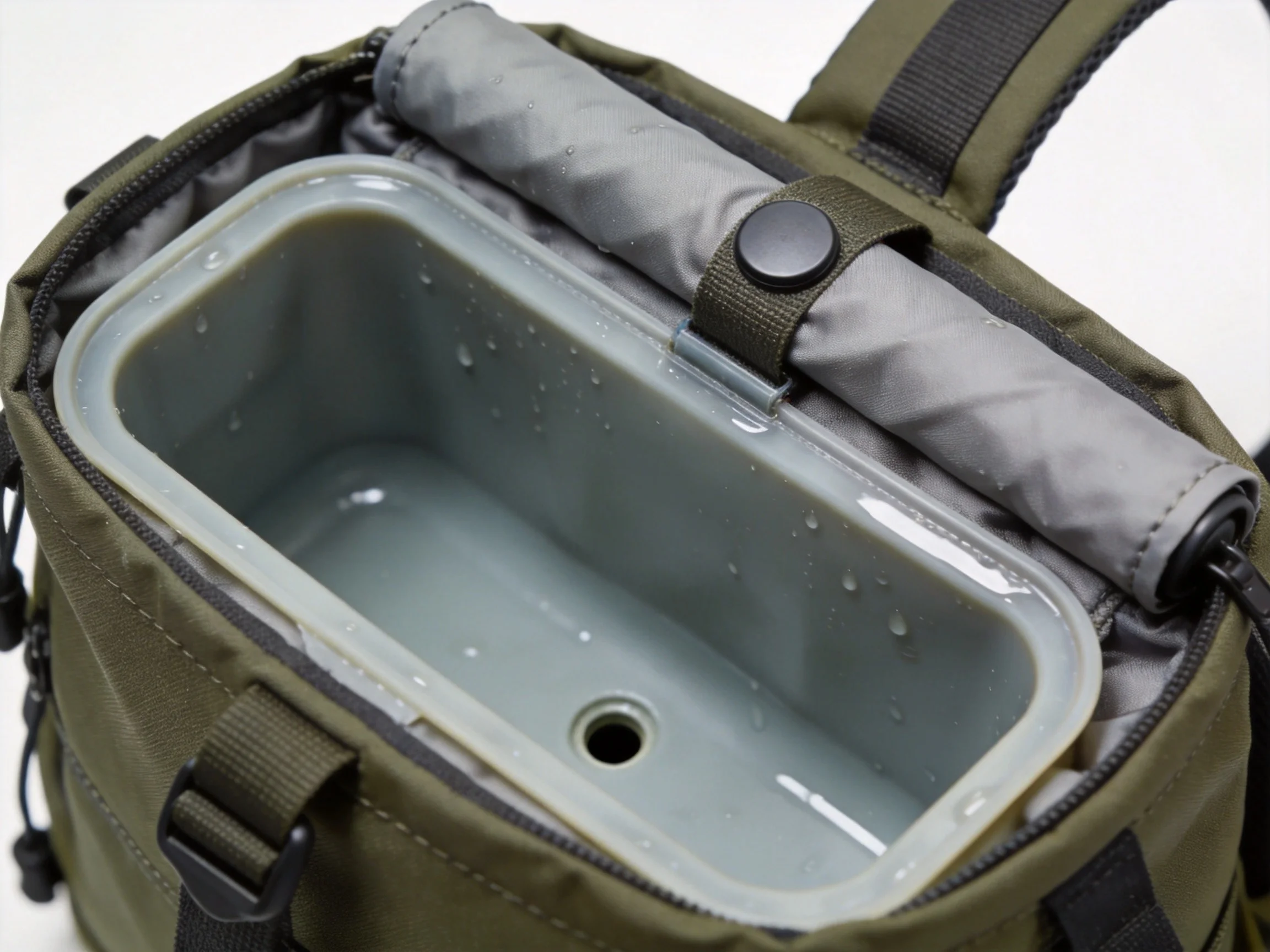 Close-up of EVA wet-umbrella pocket with drain hole inside backpack