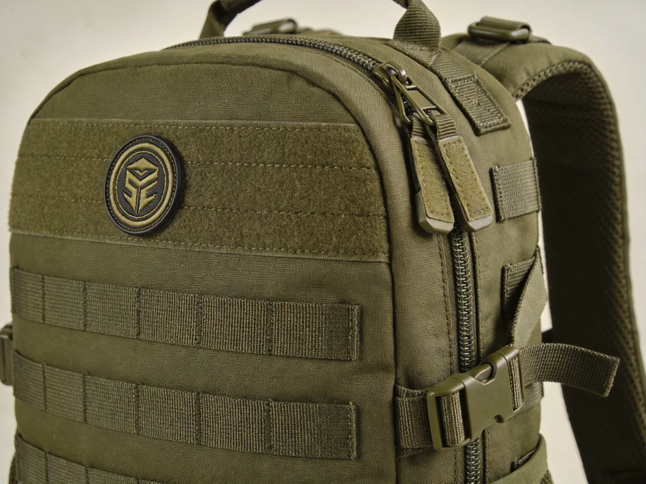 embroidered logo and MOLLE webbing detail on a custom tactical backpack with reinforced straps