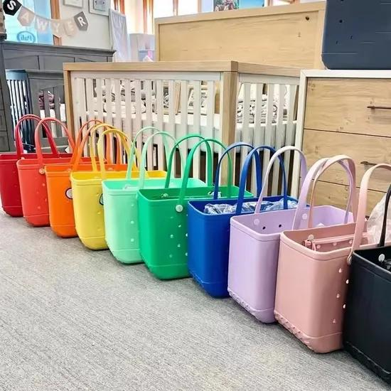 Rainbow-colored EVA foam beach totes displayed in retail setting showing the wide color range available for budget Bogg Bag alternatives